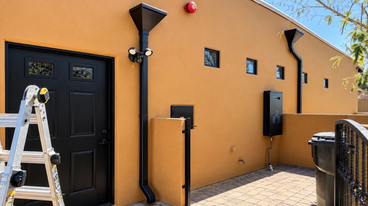 Black box downspouts and collector heads on a commercial building elevation in Arizona